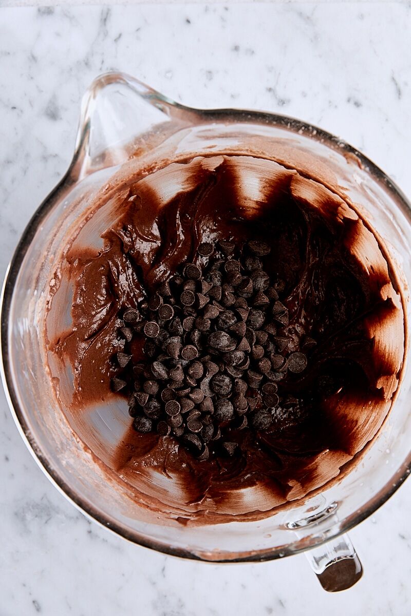 Semisweet and bittersweet chocolate chips added to batter in glass mixing bowl