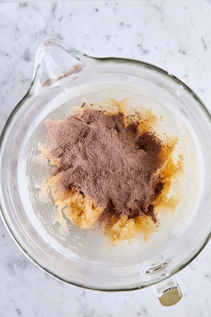 Dry ingredients added to batter in glass mixing bowl
