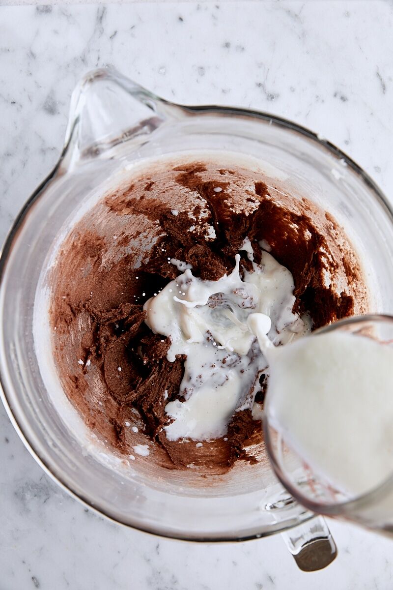 Wet ingredients added to batter in glass mixing bowl