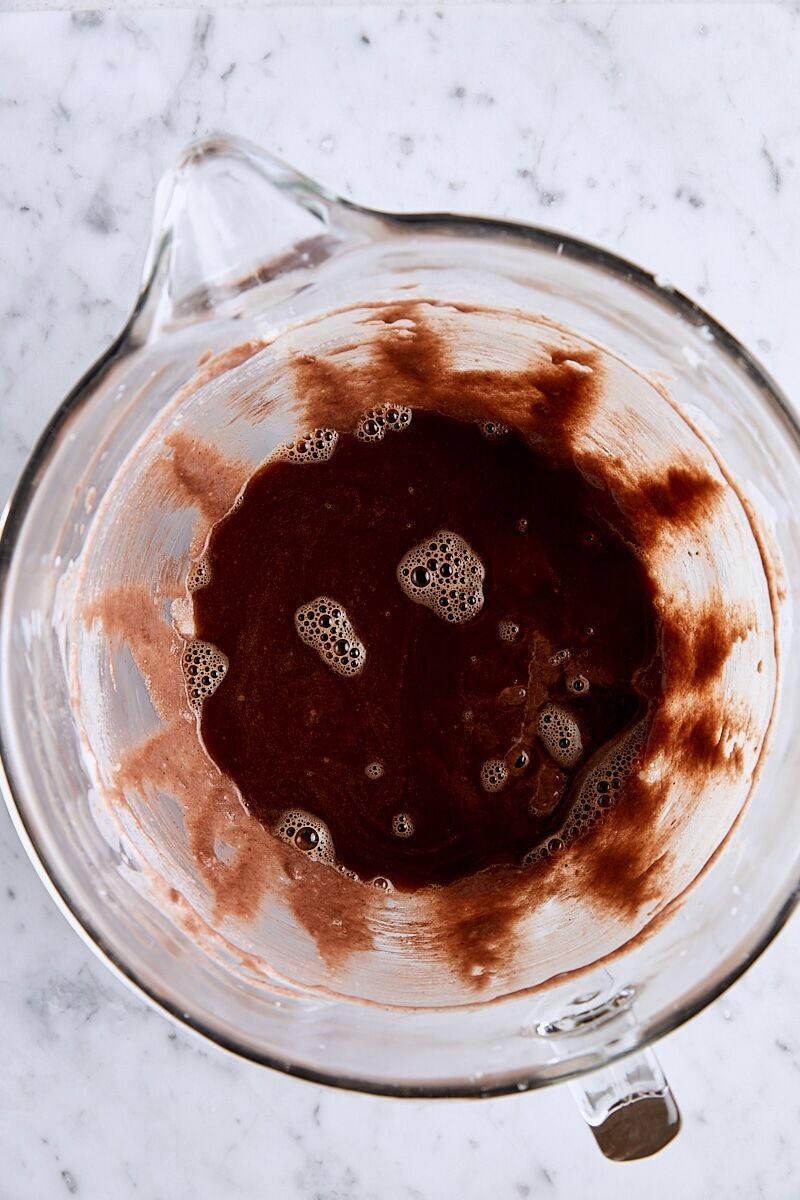 Espresso and boiling water added to batter in glass mixing bowl