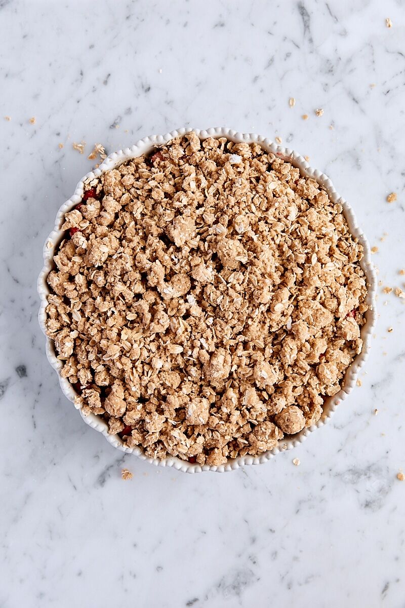 Assembled strawberry crisp in white baking dish