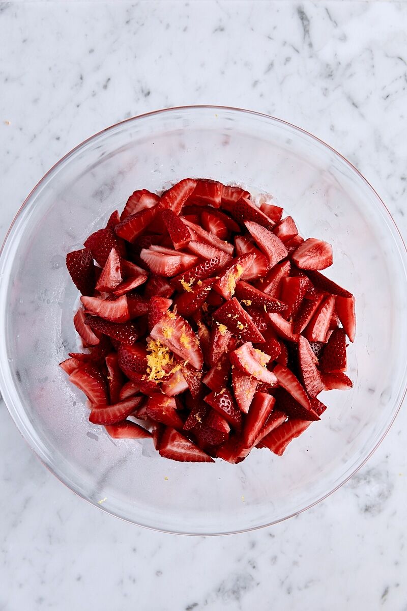 Strawberries, lemon zest, lemon juice, granulated sugar, arrowroot starch, and salt in glass bowl