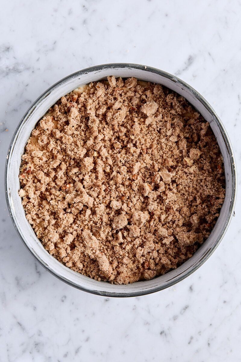 Coffee cake batter sprinkled with half of the streusel topping