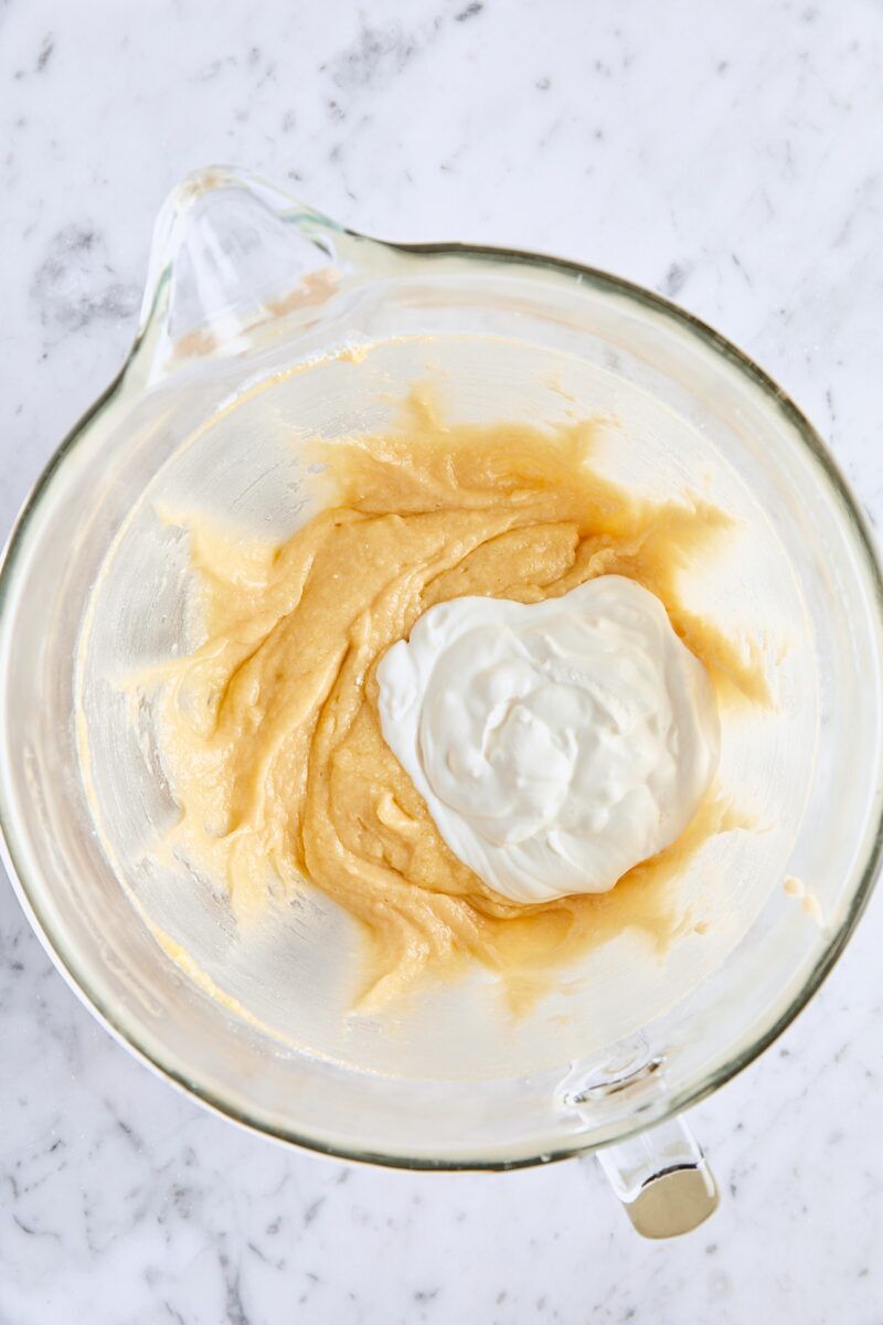 Wet ingredients added to batter in glass mixing bowl