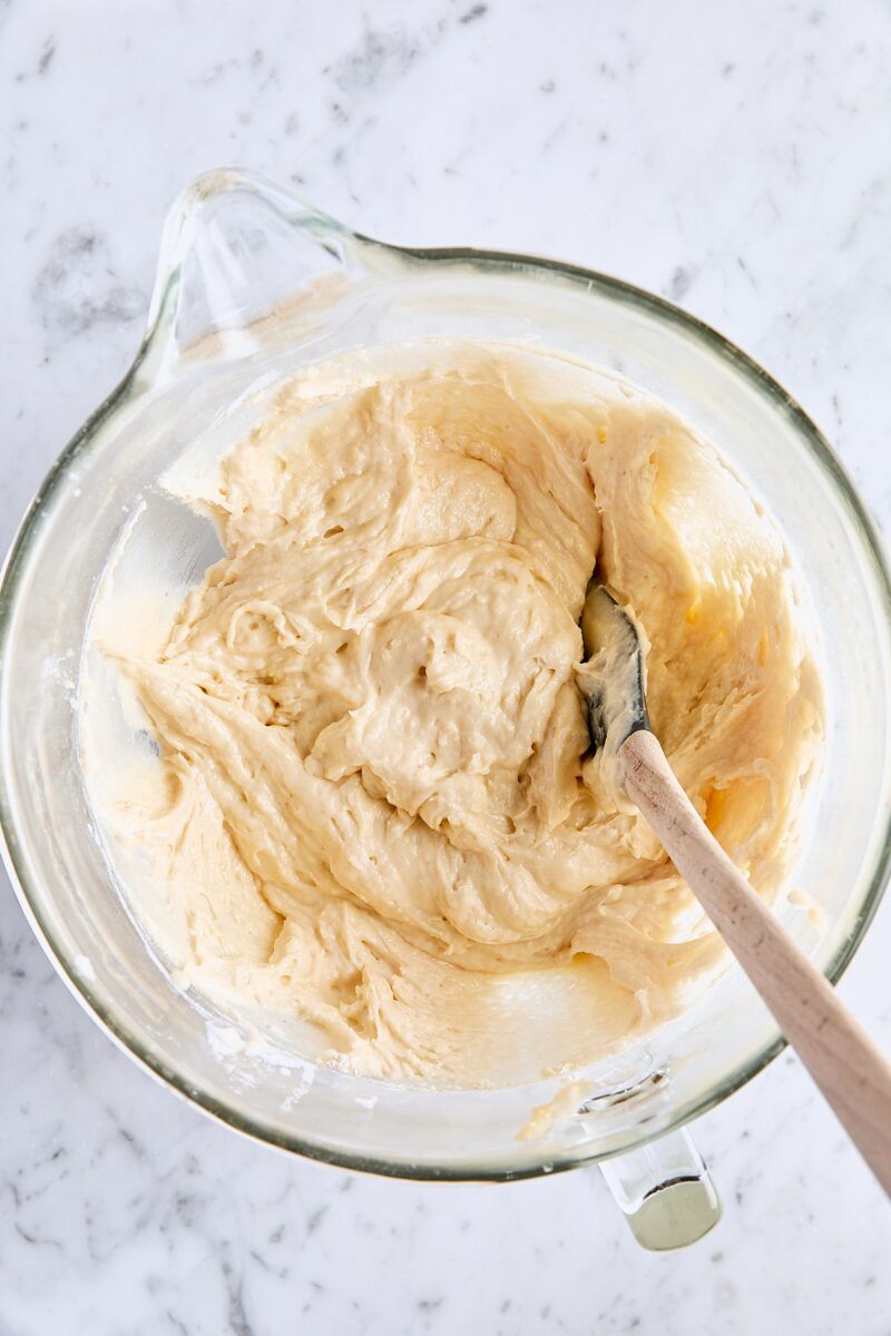 Sour cream coffee cake batter in glass mixing bowl with spatula