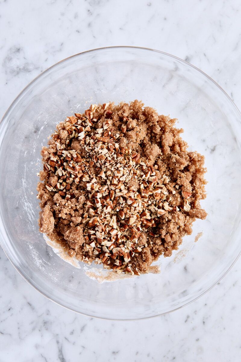 Chopped pecans added to streusel topping in glass bowl