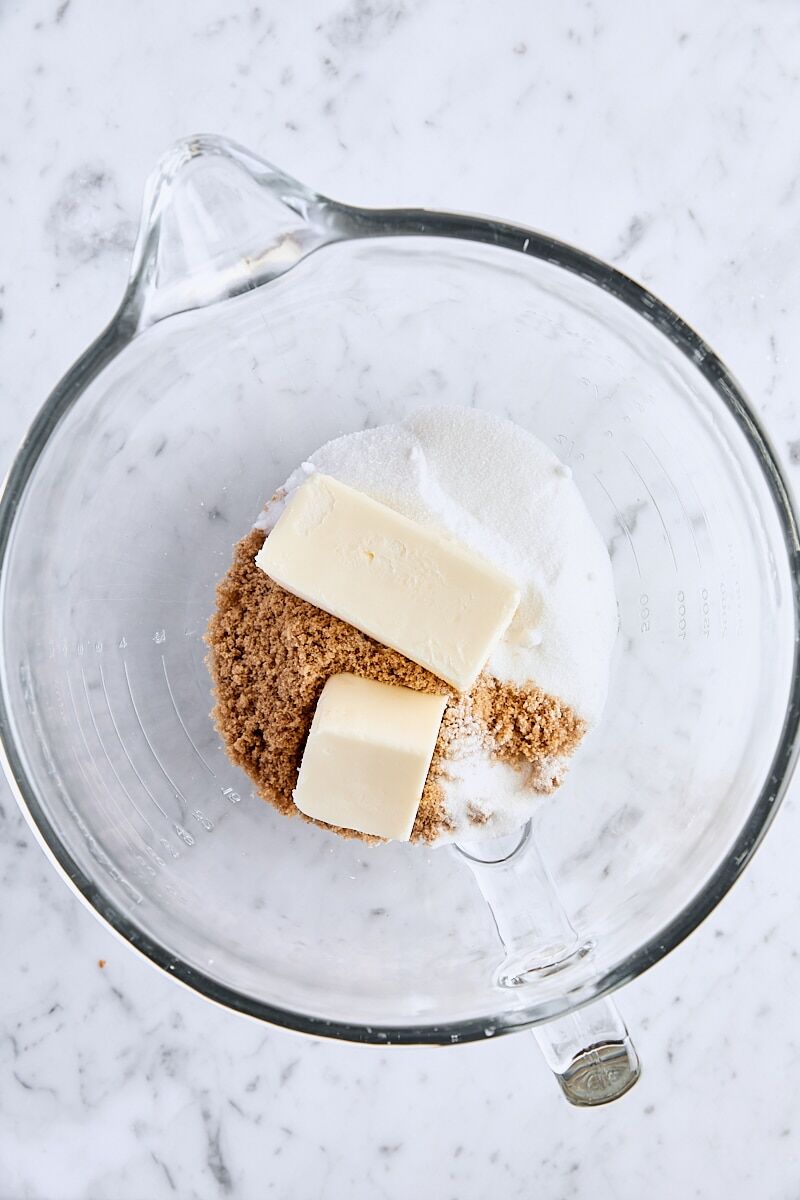 Unsalted butter, dark brown sugar, and granulated sugar in glass mixing bowl