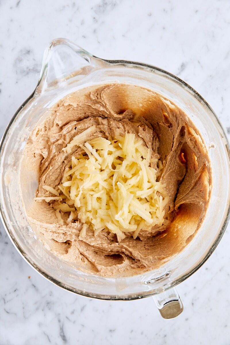 Shredded apples added to spiced bundt cake batter