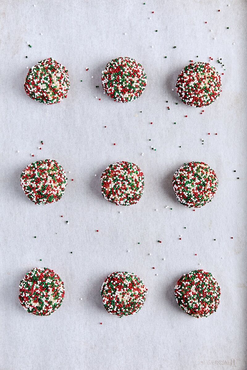 Brown butter sugar cookie dough balls scooped onto parchment-lined baking sheet