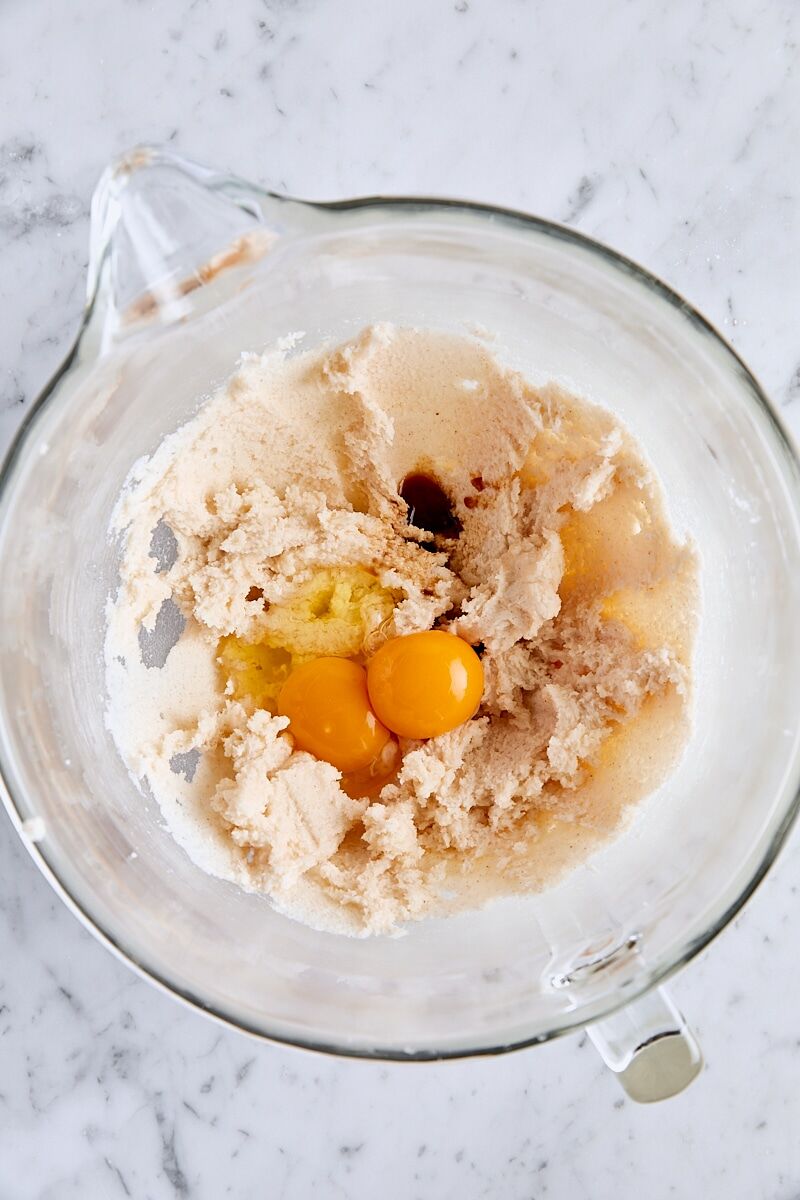 Egg, egg yolk, and vanilla extract added to glass mixer bowl