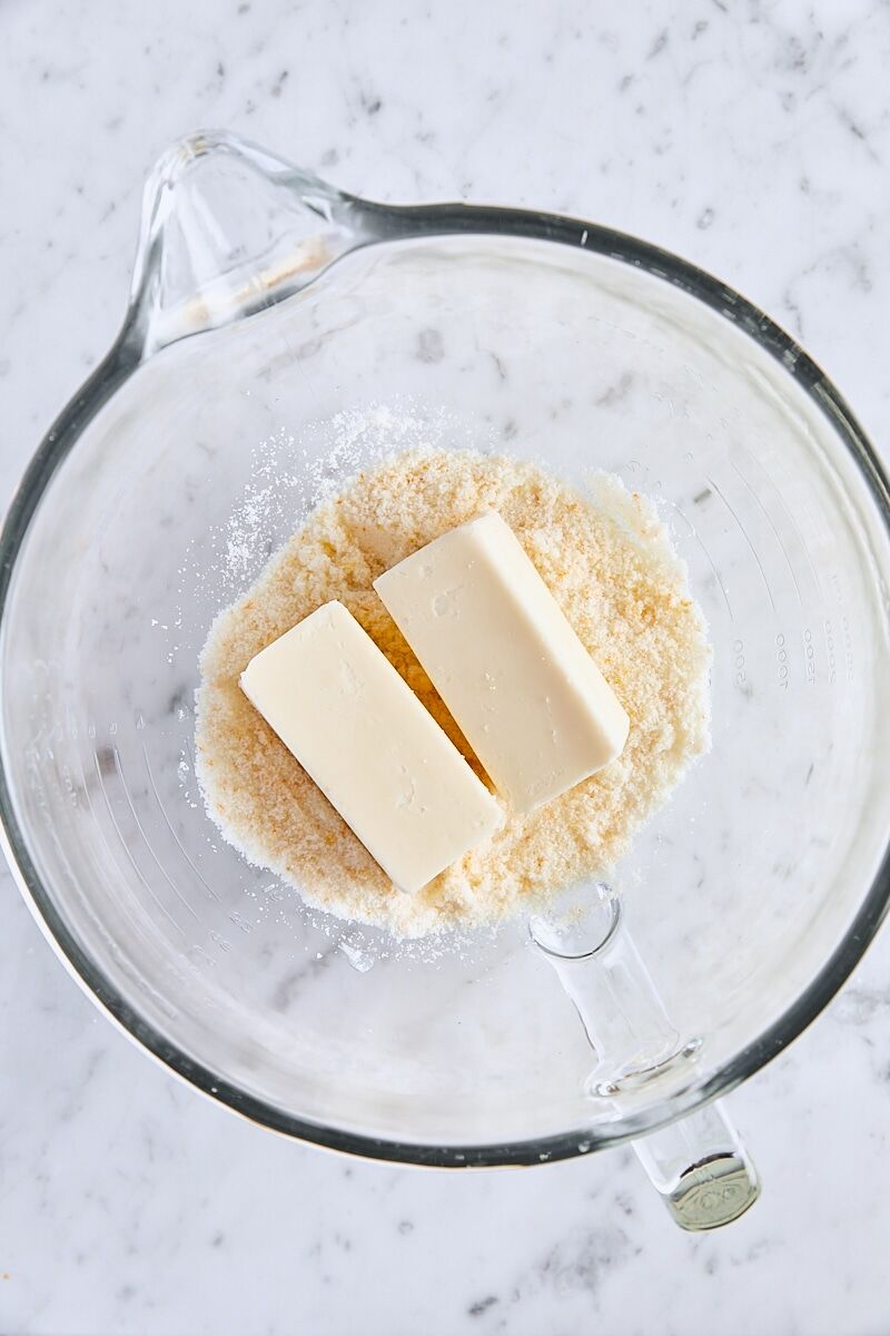 Room temperature butter and orange-sugar in glass mixer bowl