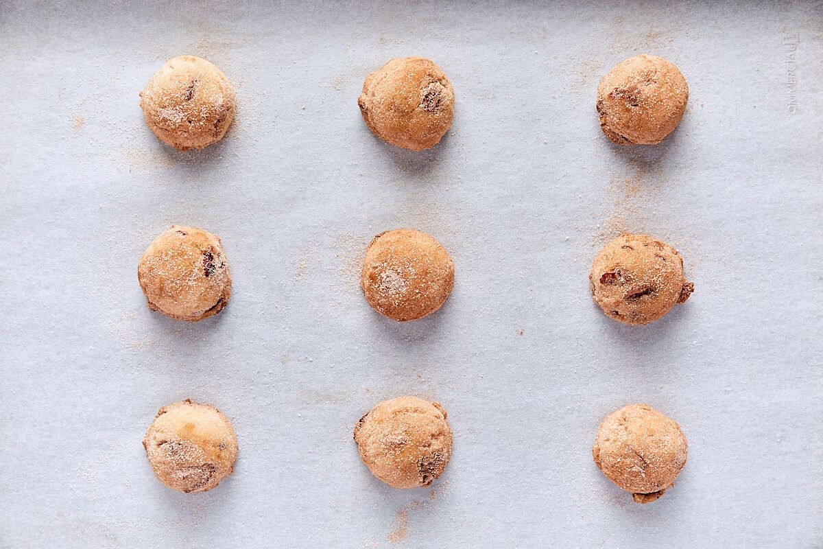 Cranberry snickerdoodle dough balls scooped onto parchment-lined baking sheet
