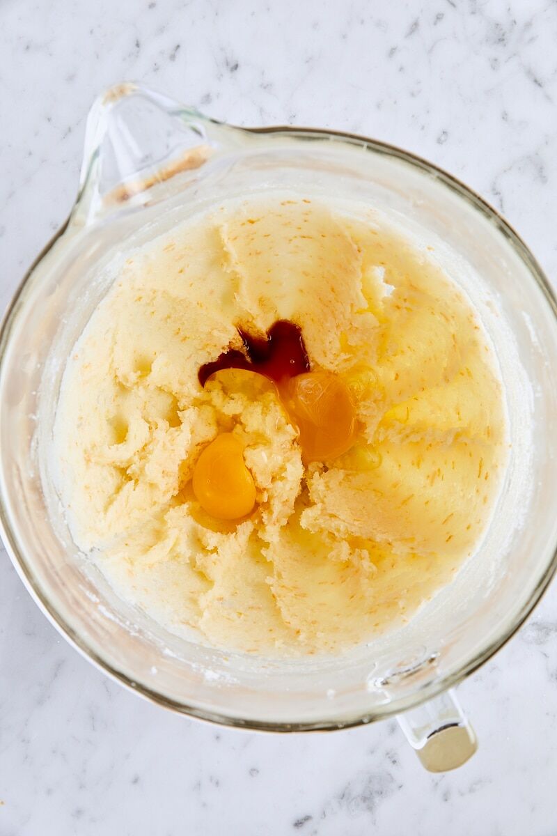 Egg, egg yolk, and vanilla extract added to glass mixer bowl