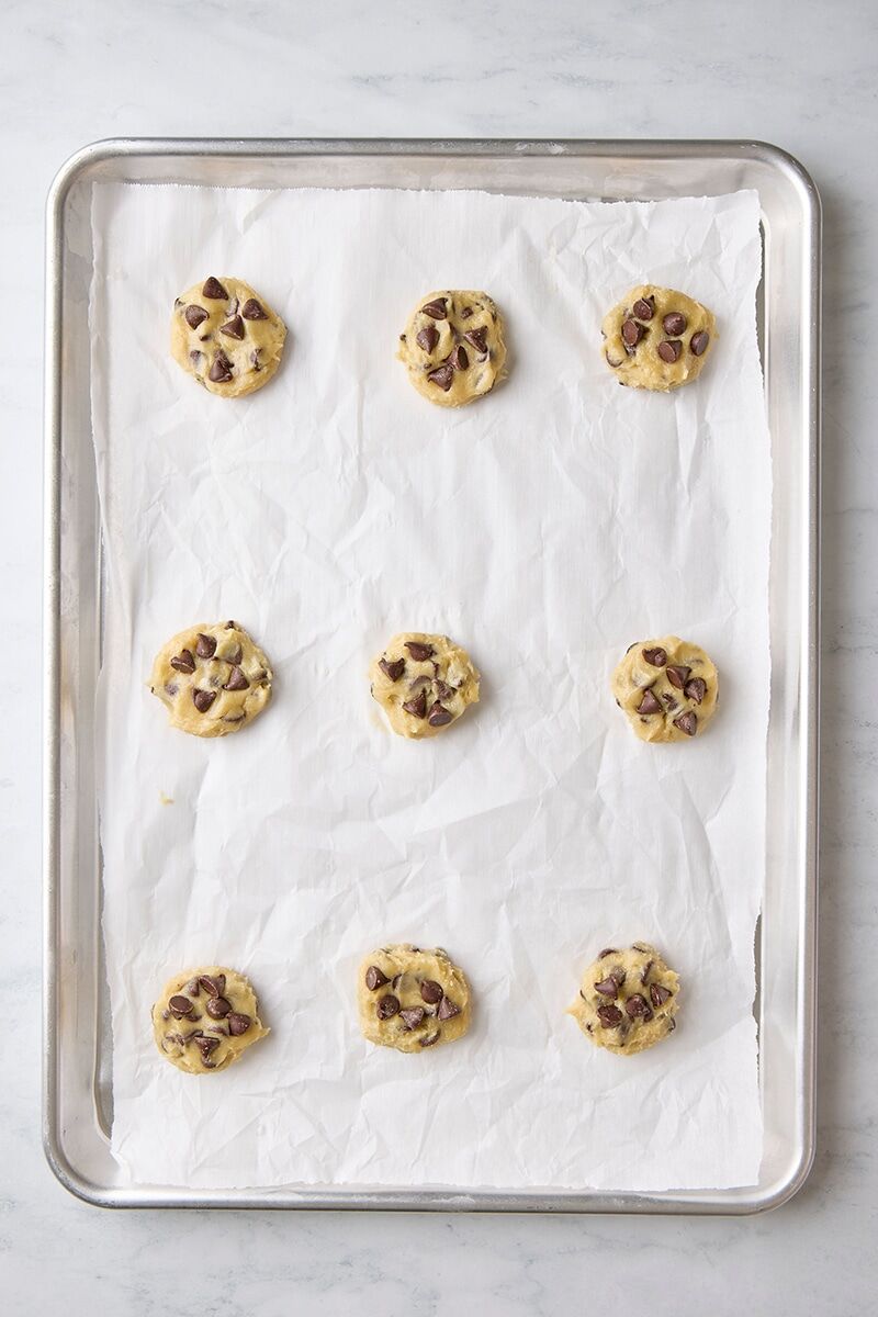 Scooped cookie dough balls on parchment-lined baking sheet