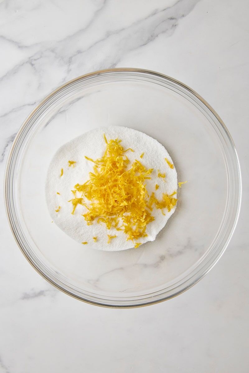 Granulated sugar and lemon zest in glass bowl