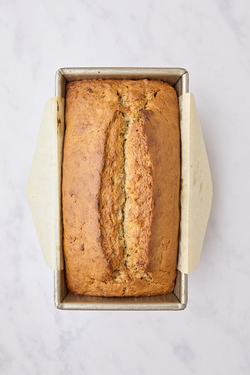 Baked banana bread in parchment-lined loaf pan