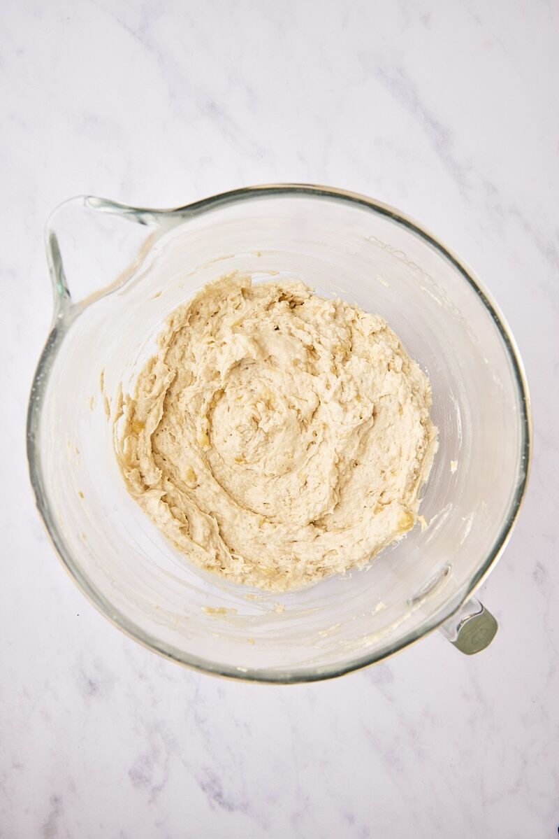 Mixed banana bread batter in glass mixer bowl