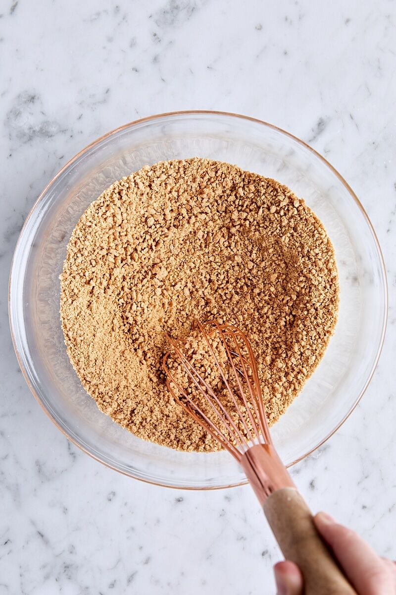 Graham crust ingredients whisked together in glass bowl