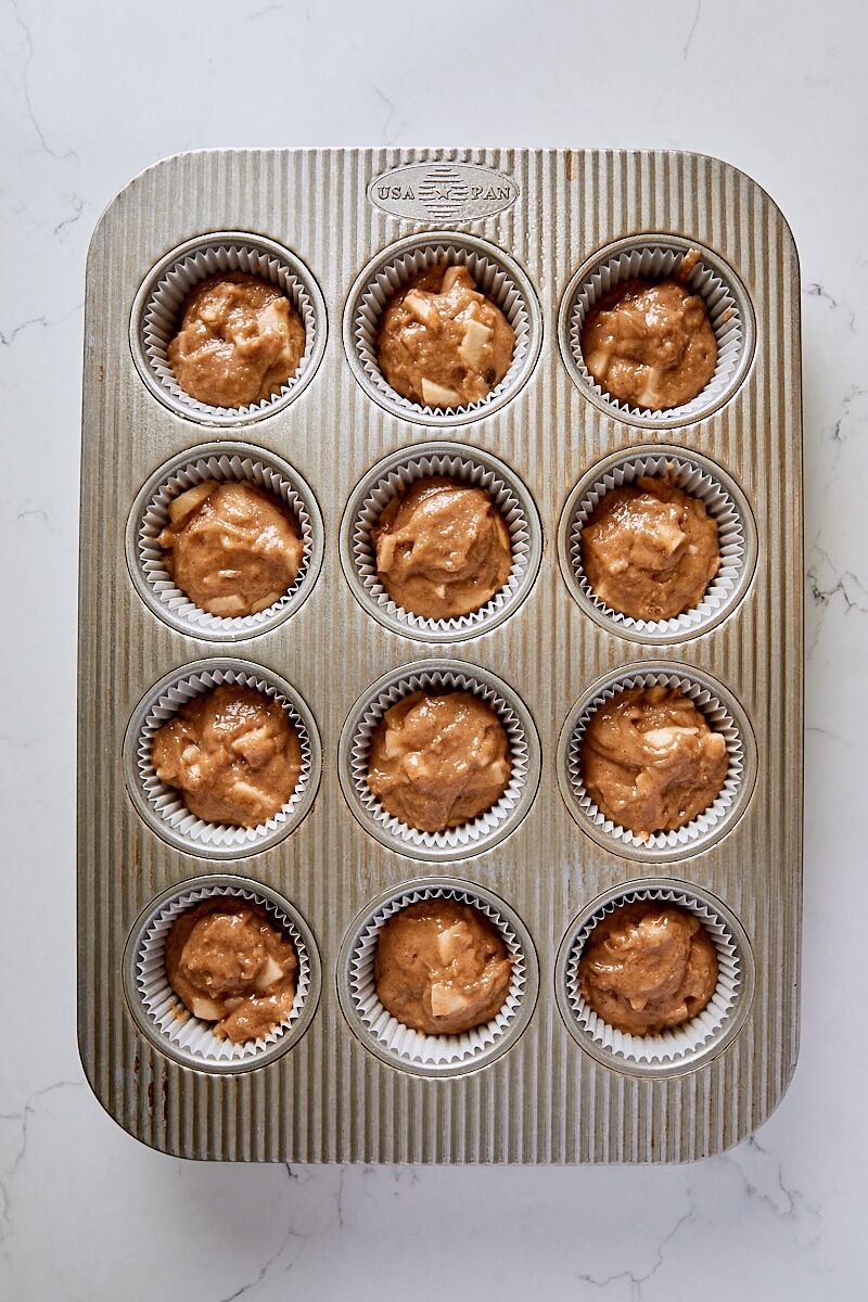 Muffin batter scooped into muffin tin