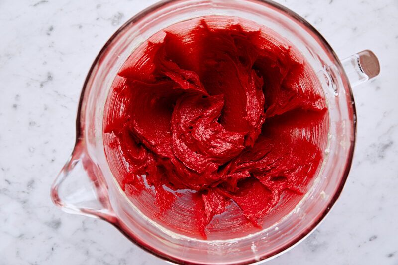 Red gel food coloring added to batter in glass mixing bowl