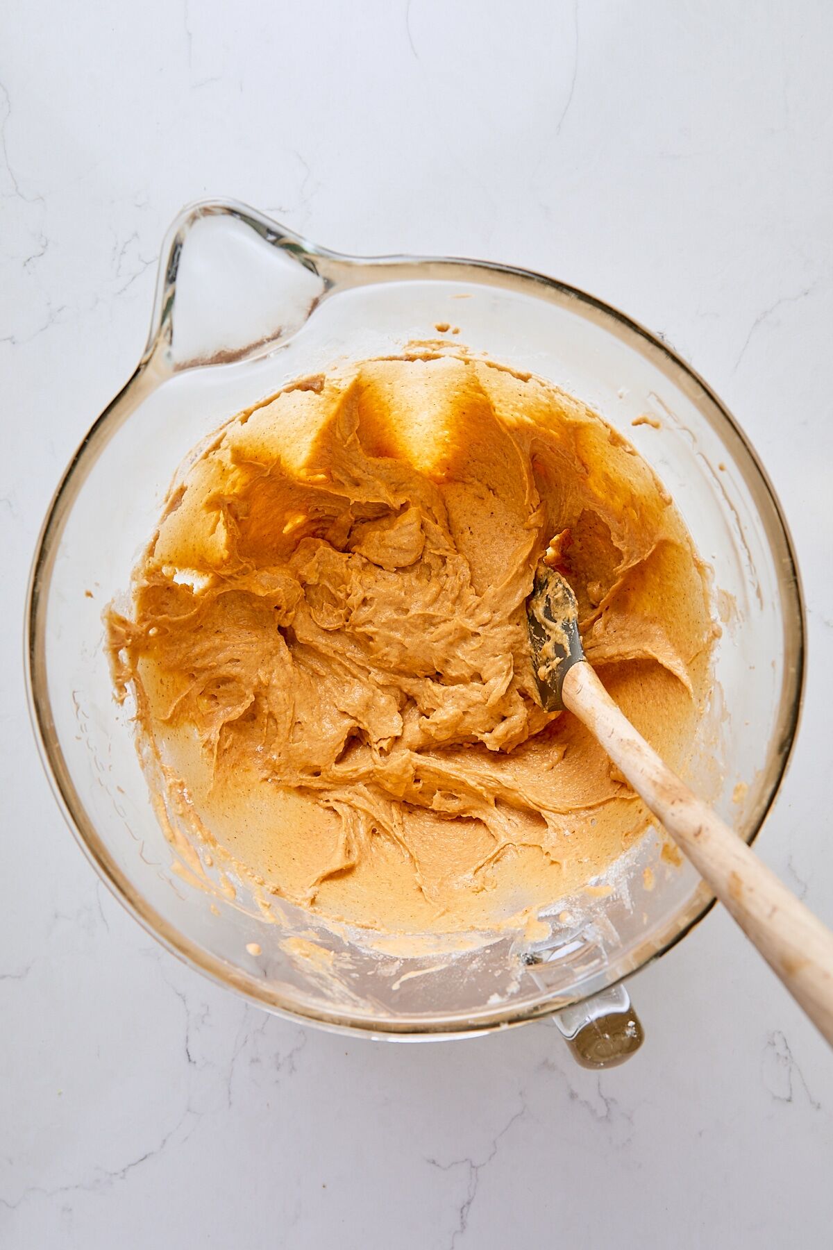 Mélange de gâteau à la citrouille dans le bol en verre d'un batteur sur socle