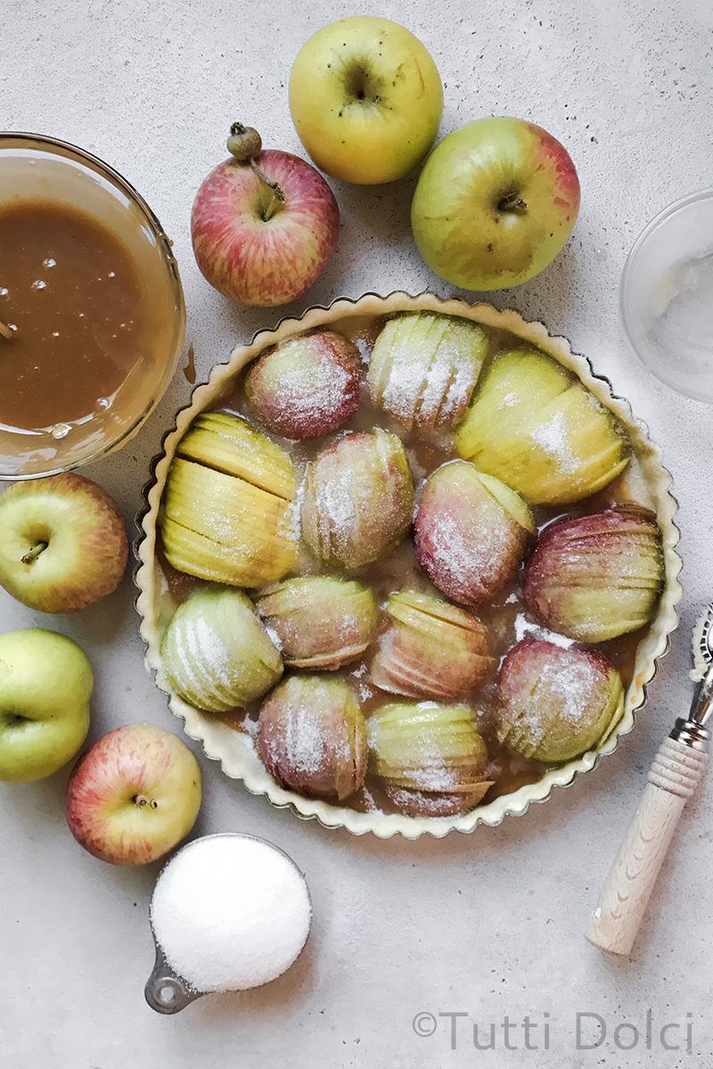 Sliced apples tightly arranged in tart shell and sprinkled with sugar