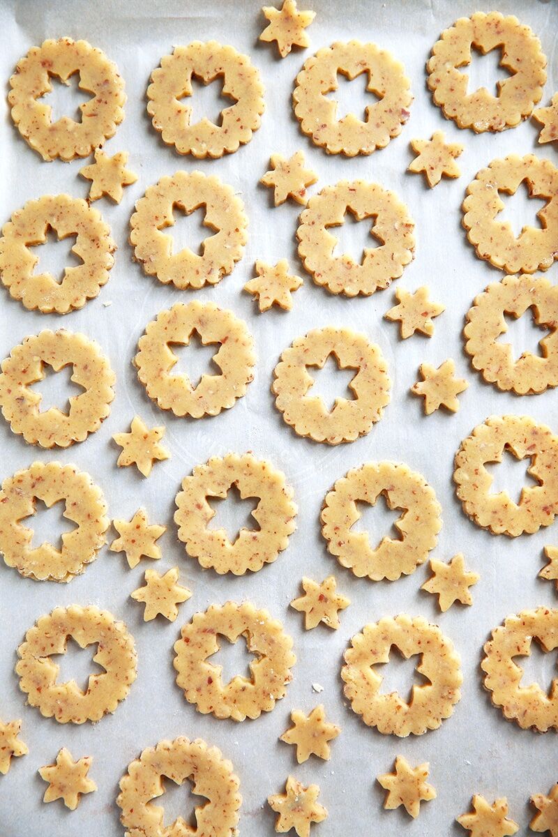 Unbaked linzer cookies punched out and arranged in a single layer on a baking sheet