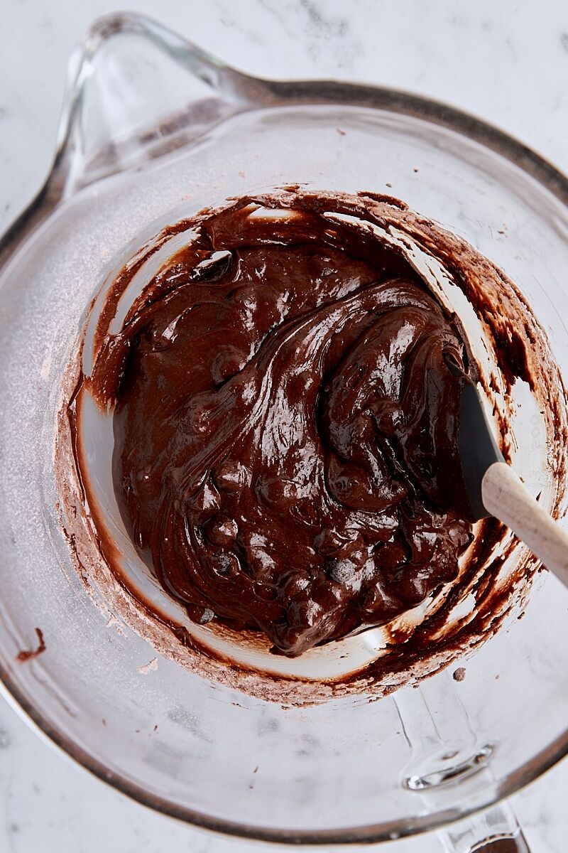 Brownie cookie dough in glass mixing bowl with spatula
