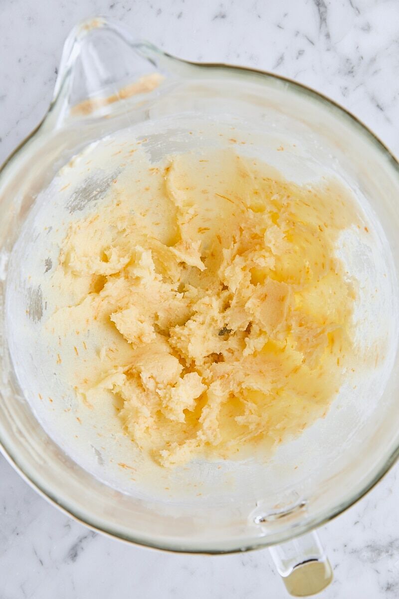 Softened butter and orange-sugar mixed together in glass mixing bowl
