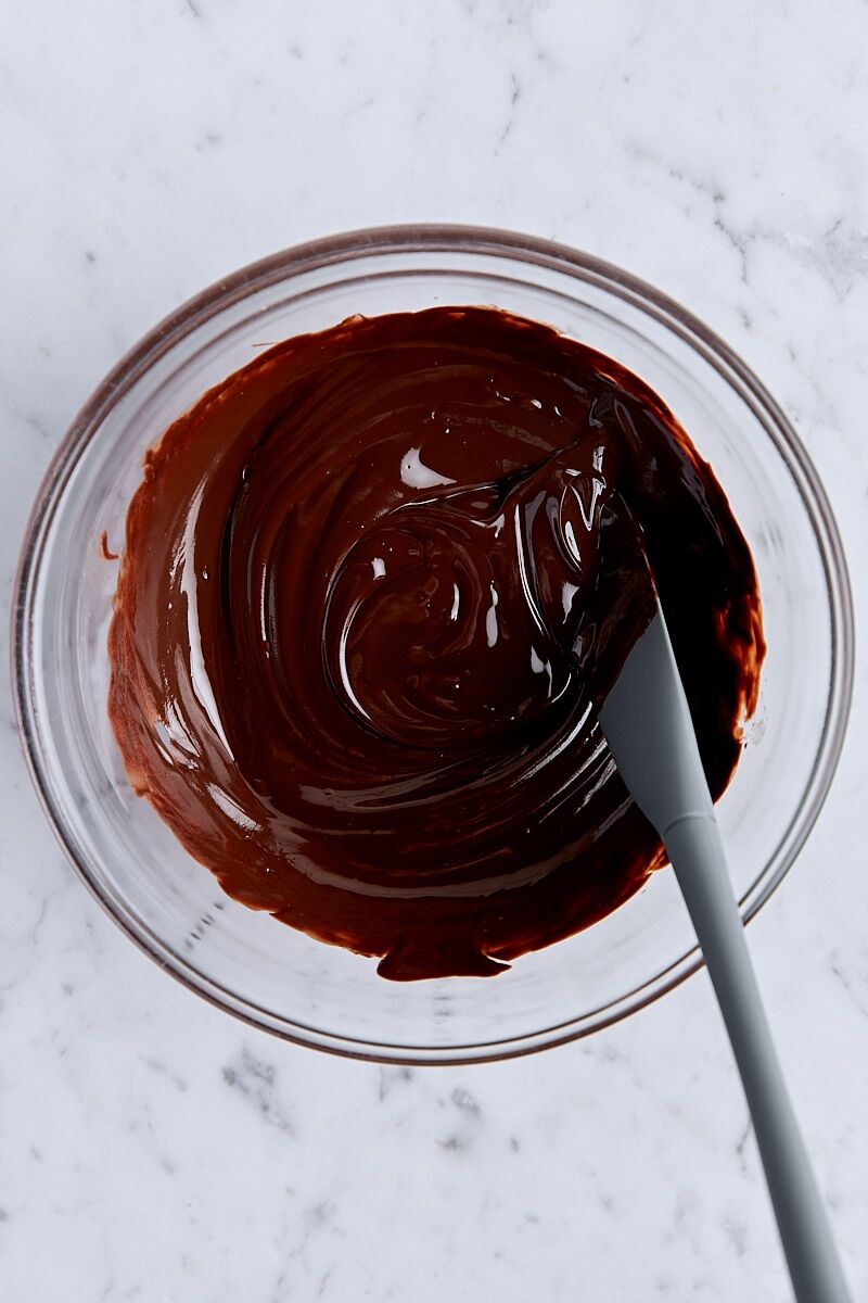 Melted butter and chocolate in glass bowl with spatula