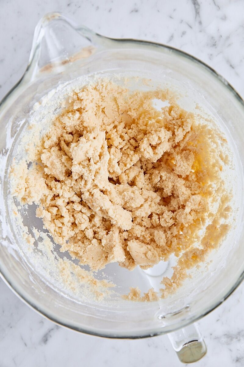 Crumbly shortbread dough in glass mixing bowl