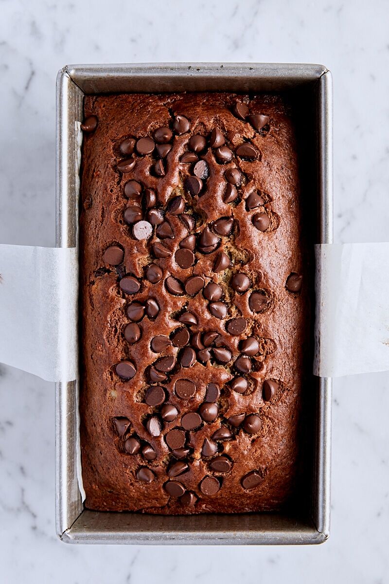 Baked chocolate chip banana bread in parchment-lined loaf pan