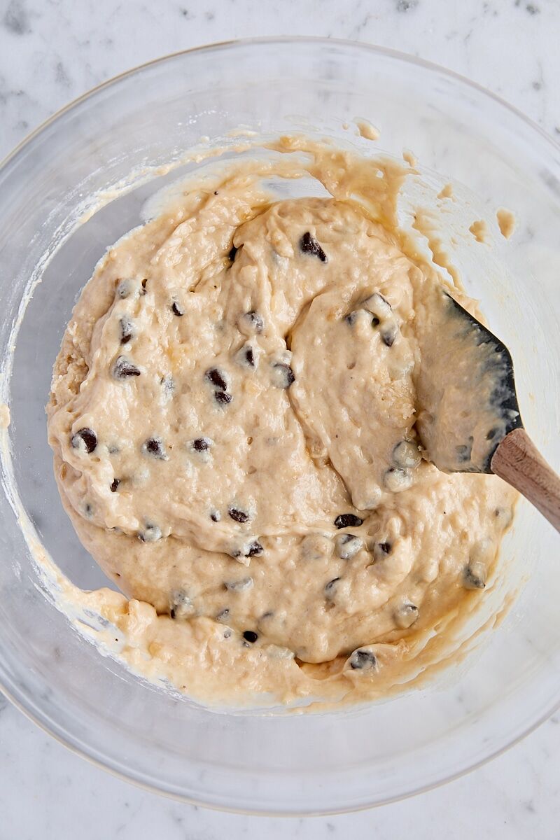 Chocolate chip banana bread batter in glass bowl with spatula