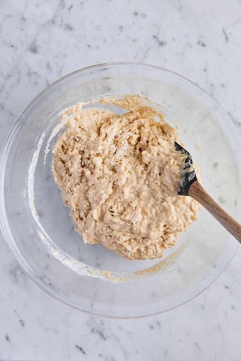Mixed banana bread batter in glass bowl with spatula