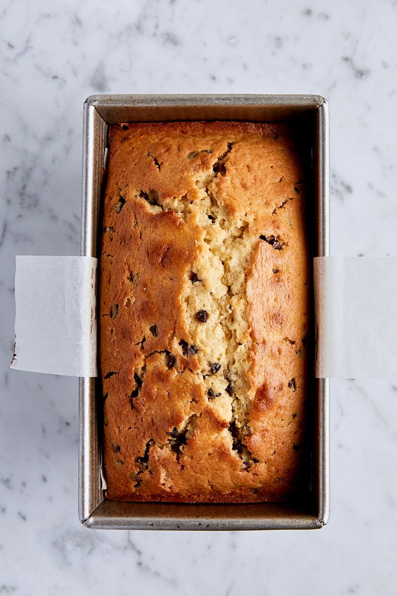 Baked chocolate chip loaf cake in parchment-lined loaf pan