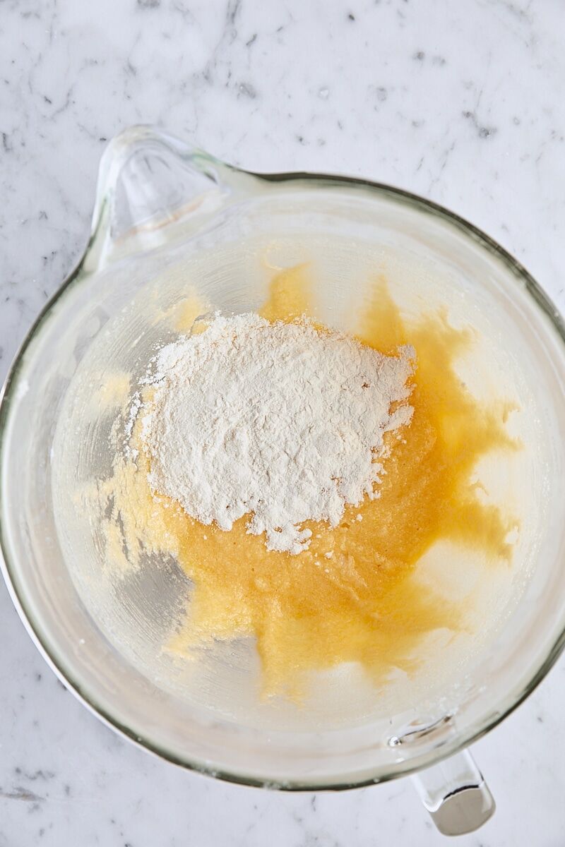 Dry ingredients added to batter in glass mixing bowl