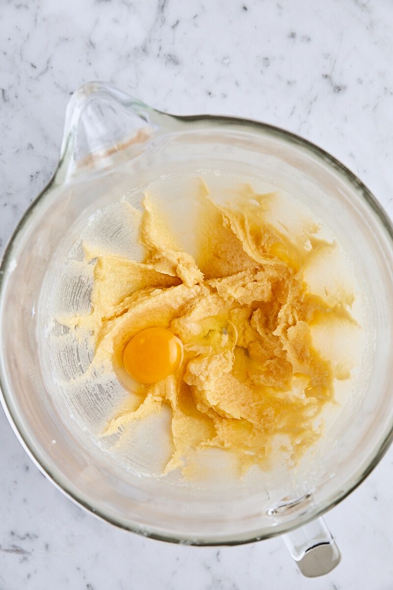 Egg added to batter in glass mixing bowl