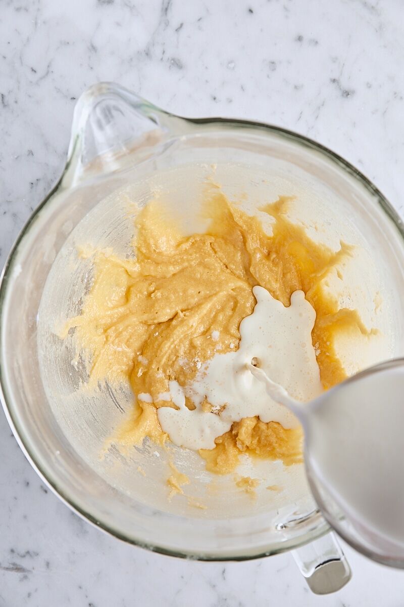 Wet ingredients added to batter in glass mixing bowl