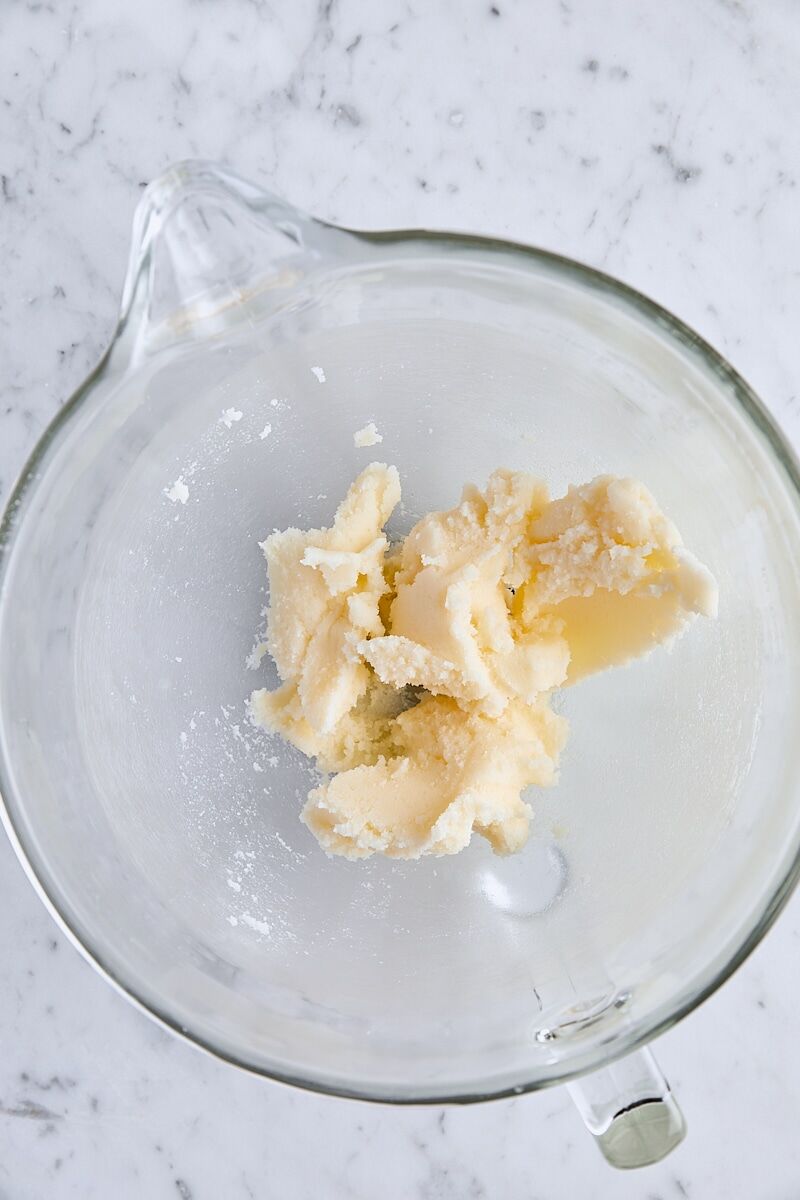 Butter and granulated sugar mixed together in glass mixing bowl