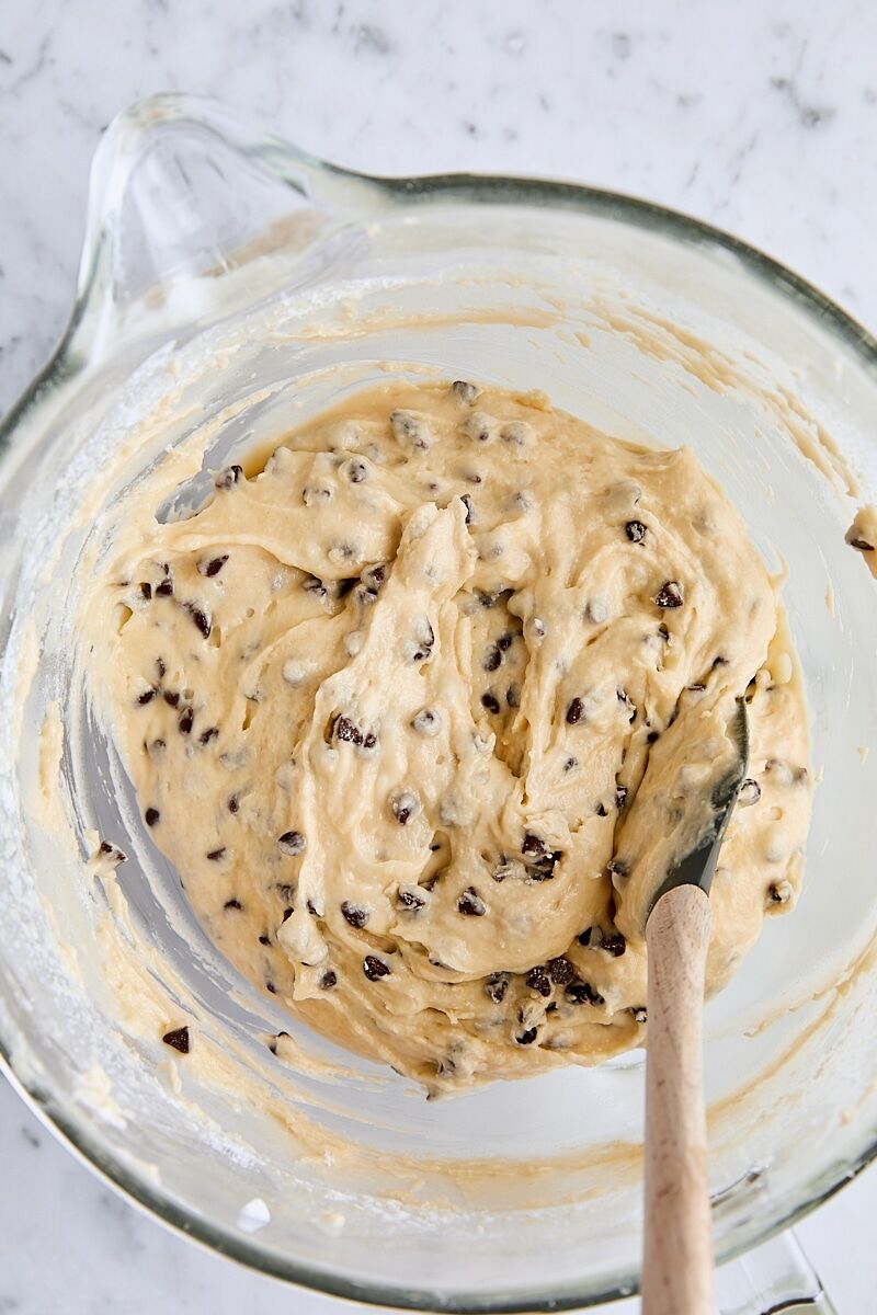 Chocolate chip loaf cake batter in glass mixing bowl with spatula