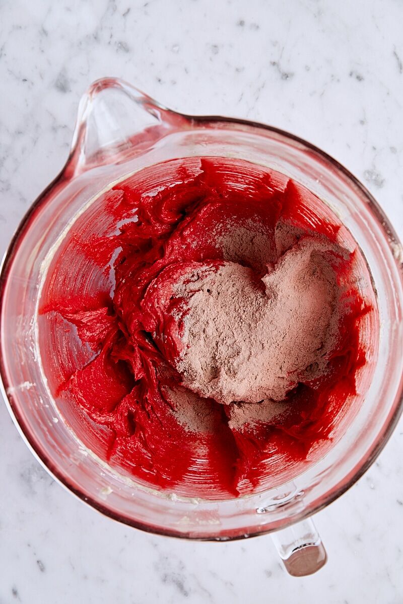 Dry ingredients added to batter in glass mixing bowl