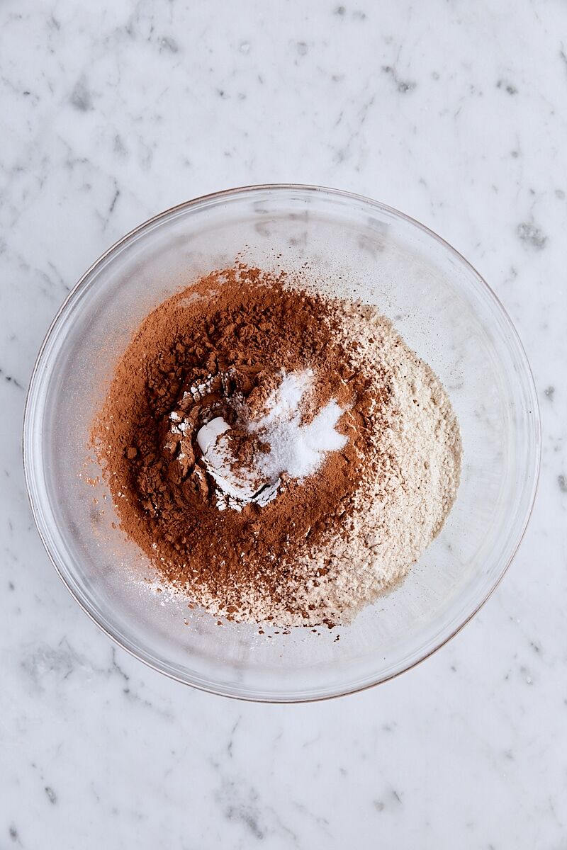 Flour, cocoa powder, baking powder, baking soda, and salt in glass bowl