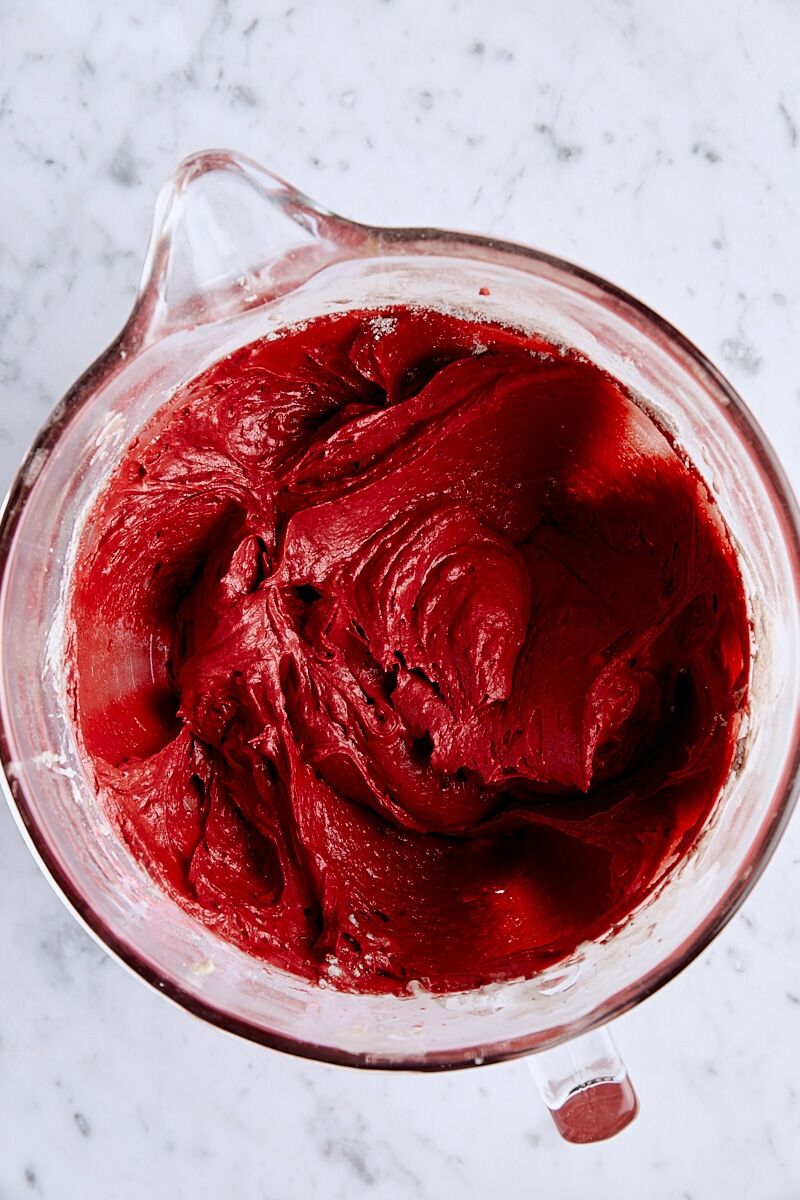 Red velvet bundt cake batter in glass mixing bowl