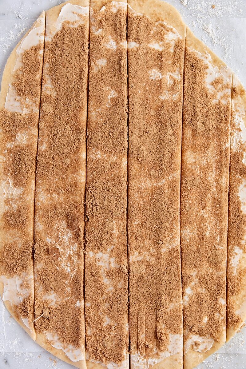 Rolled out dough topped with brown sugar-cinnamon filling and cut into six strips