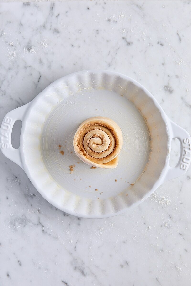 Spiral of rolled dough in center of white ceramic baking dish