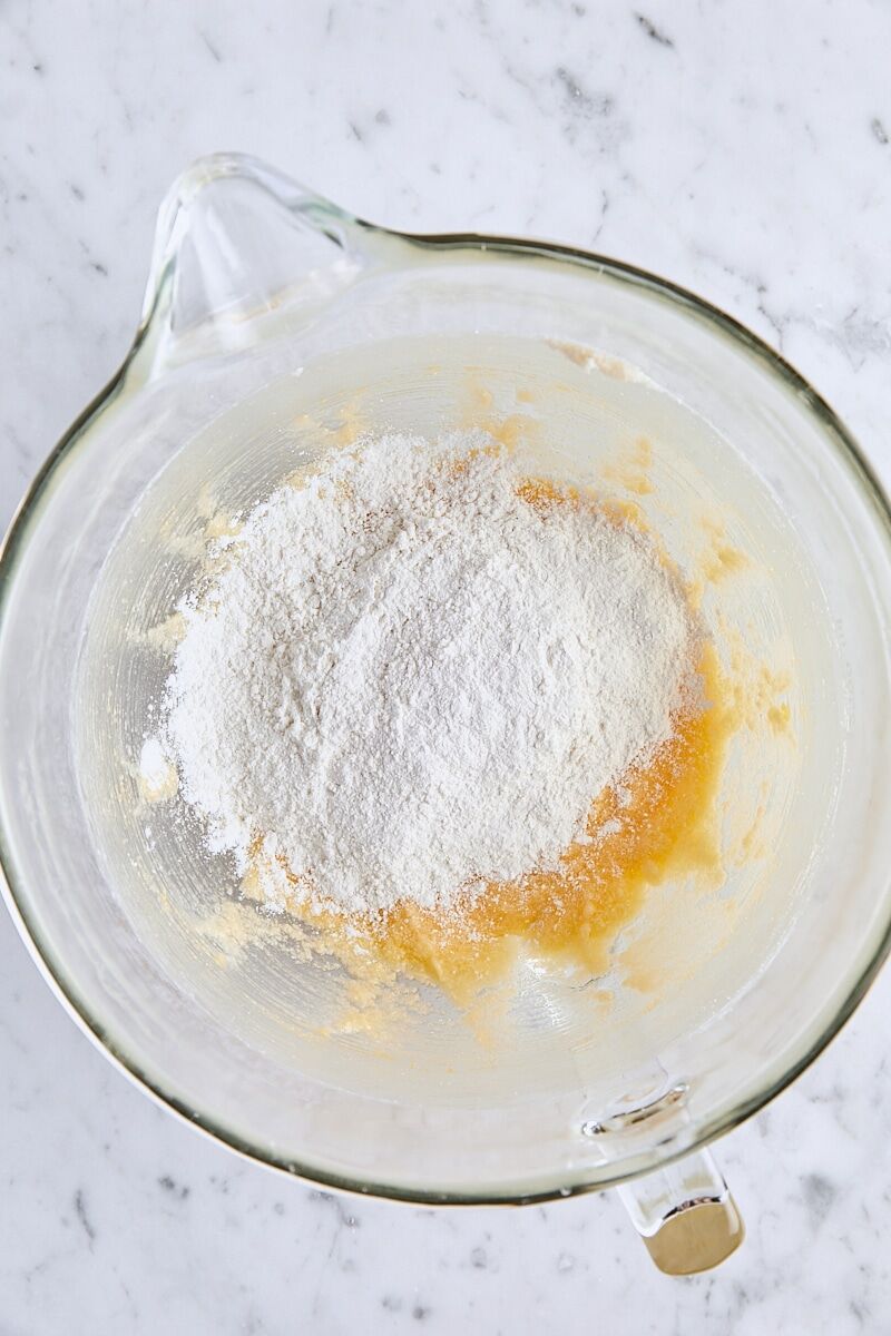 Dry ingredients added to batter in glass mixing bowl