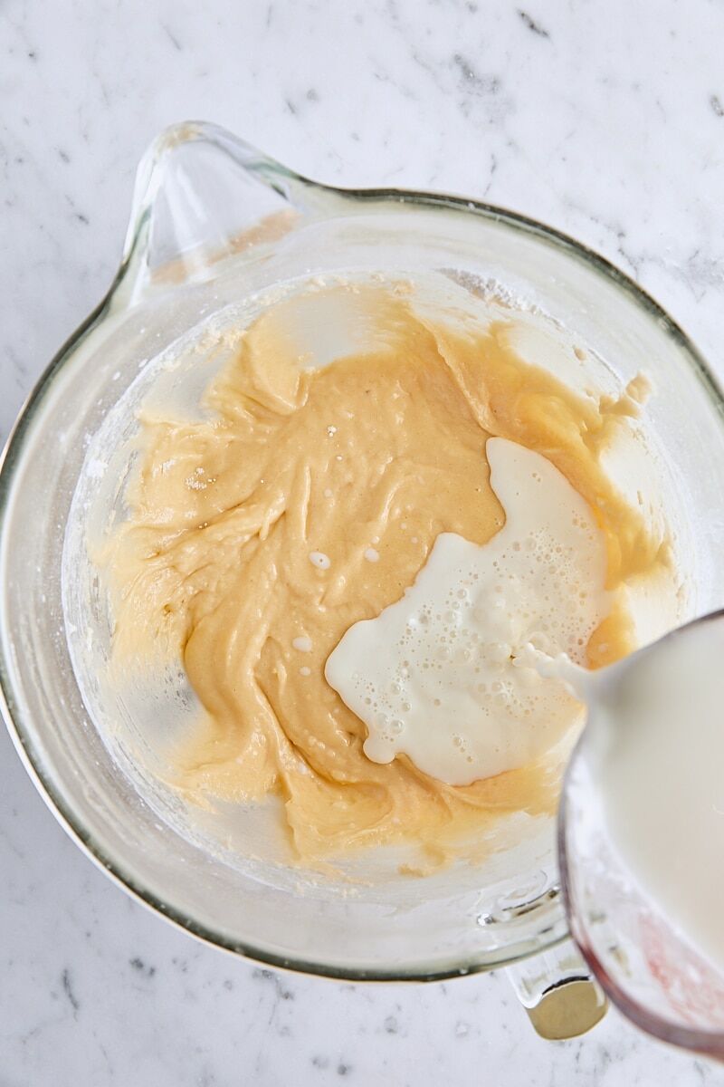 Wet ingredients added to batter in glass mixing bowl