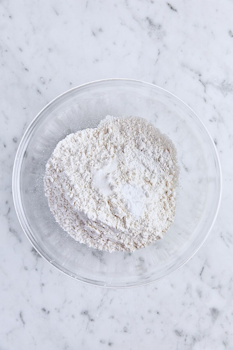 Cake flour, baking powder, baking soda, and salt in glass bowl