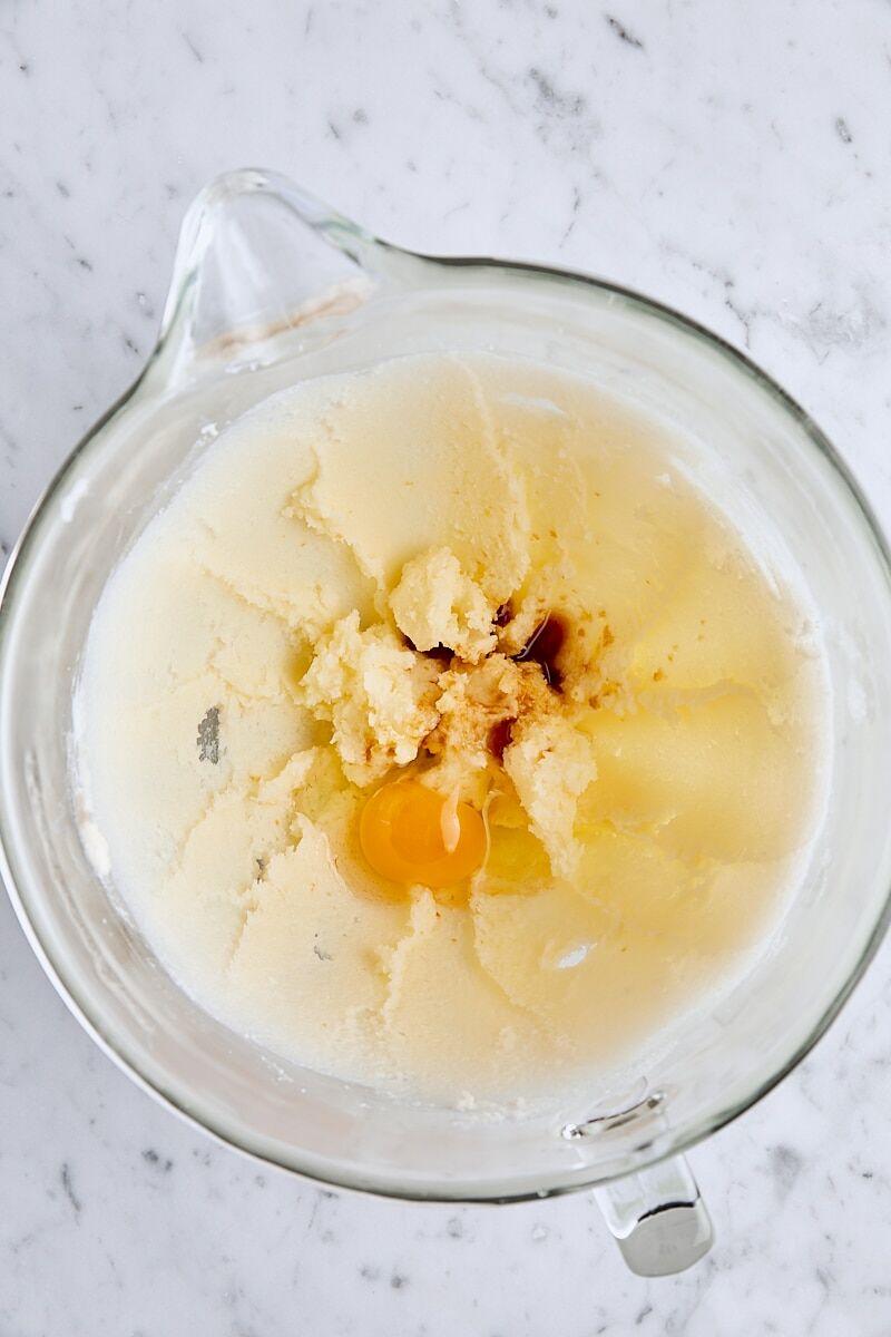 Egg, vanilla extract, and peppermint extract added to dough in glass mixing bowl