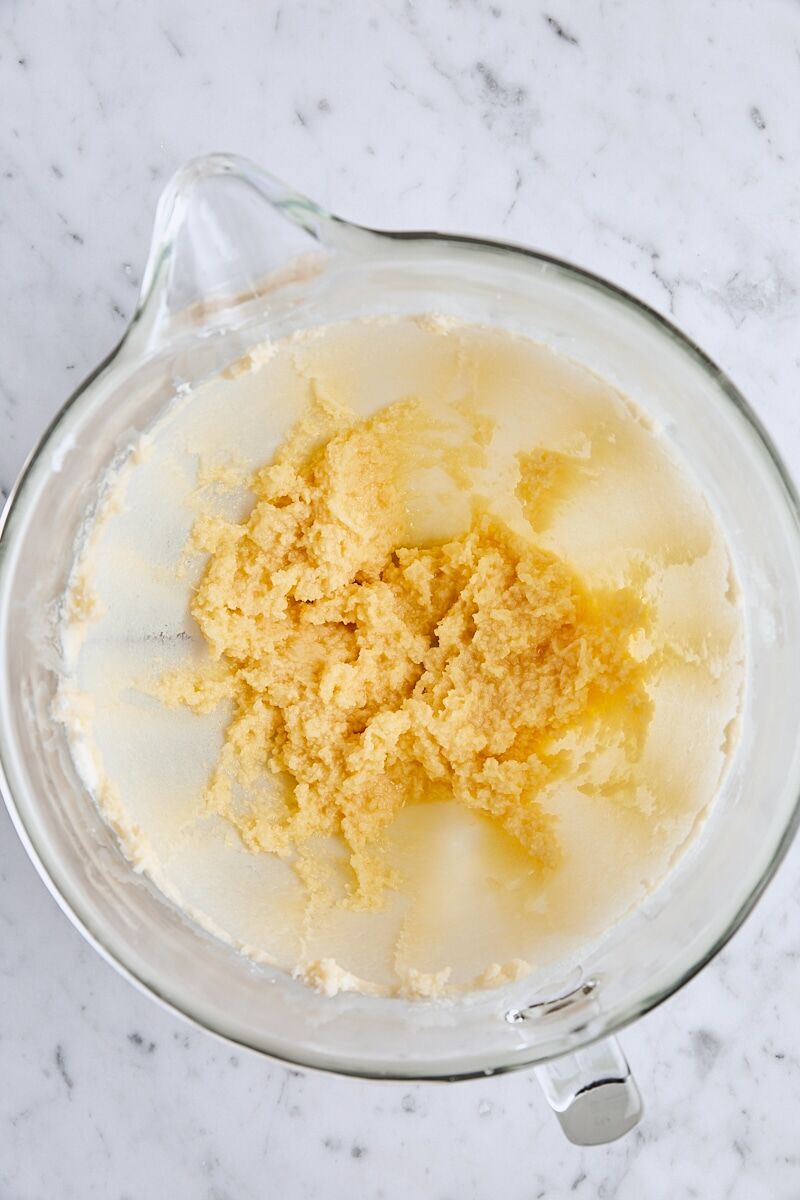 Egg and extracts mixed with butter and sugar in glass mixing bowl